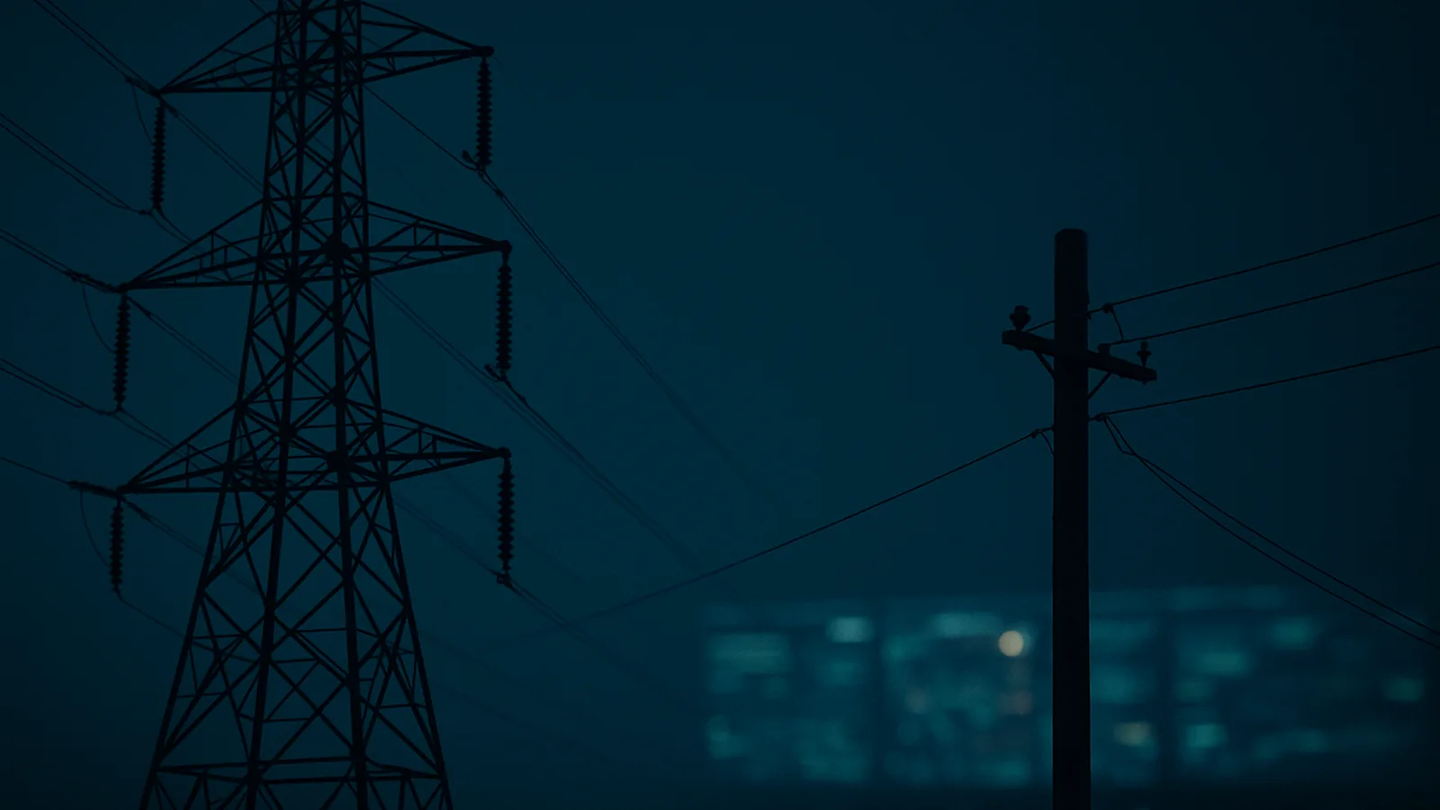 A large transmission pylon beside a small local distribution pole, showing the layers of the grid